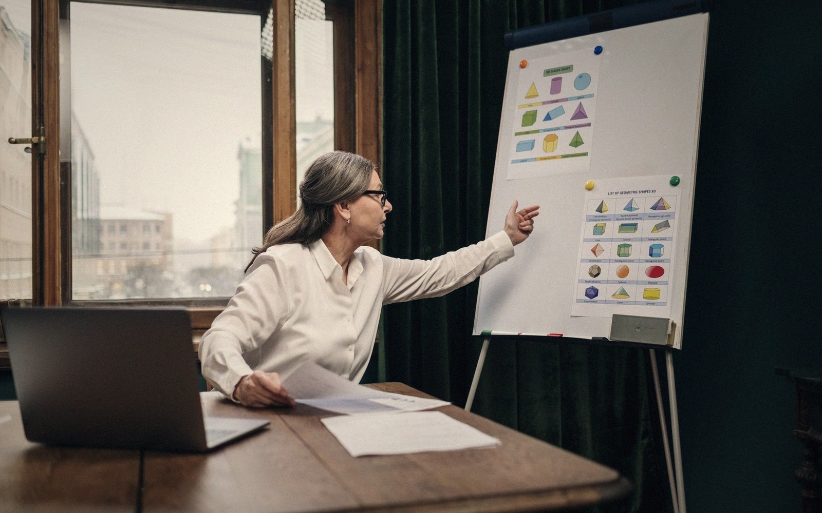 A mid-century civil-defence film still showing an instructor pointing at a wall chart